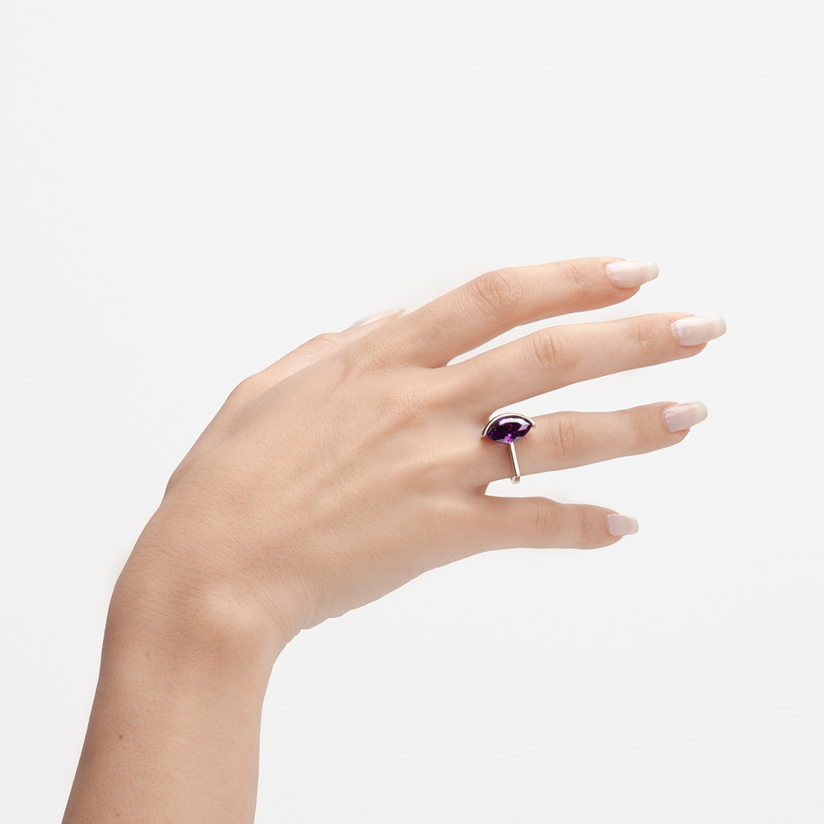 anillo artesanal Jei de plata de ley y circonita violeta en mano diseñado por Belen Bajo