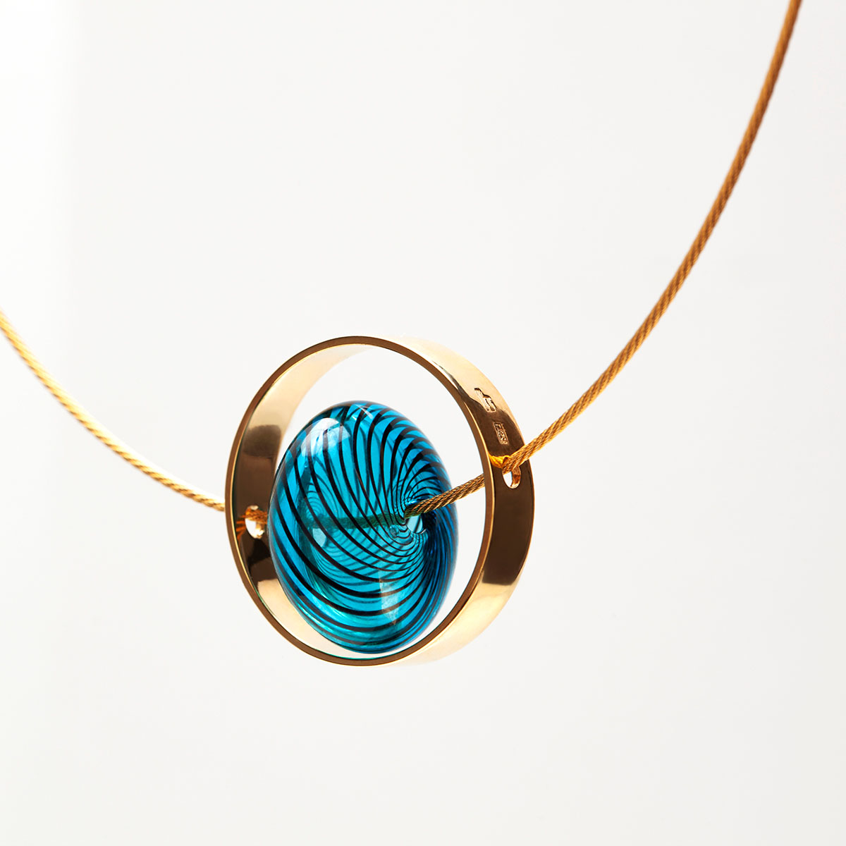 Collar artesanal Xar en plata 925 chapada en oro de 18k, vidrio azul y cable de acero galvanizado dorado diseñado por Belen Bajo